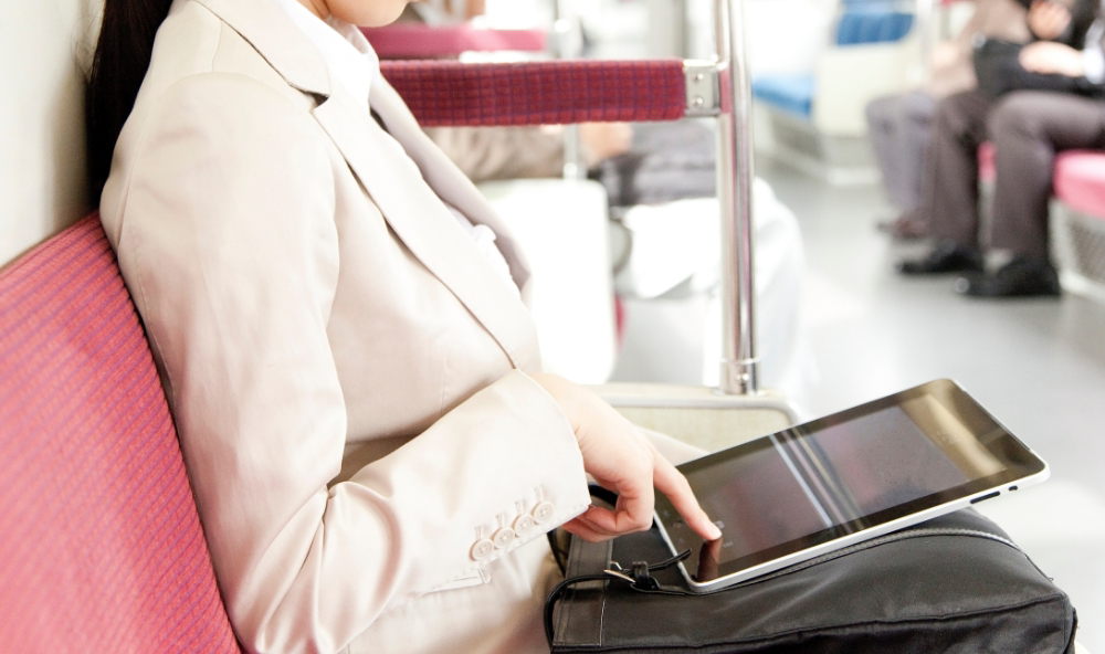 電車内でタブレットを操作する女性 image